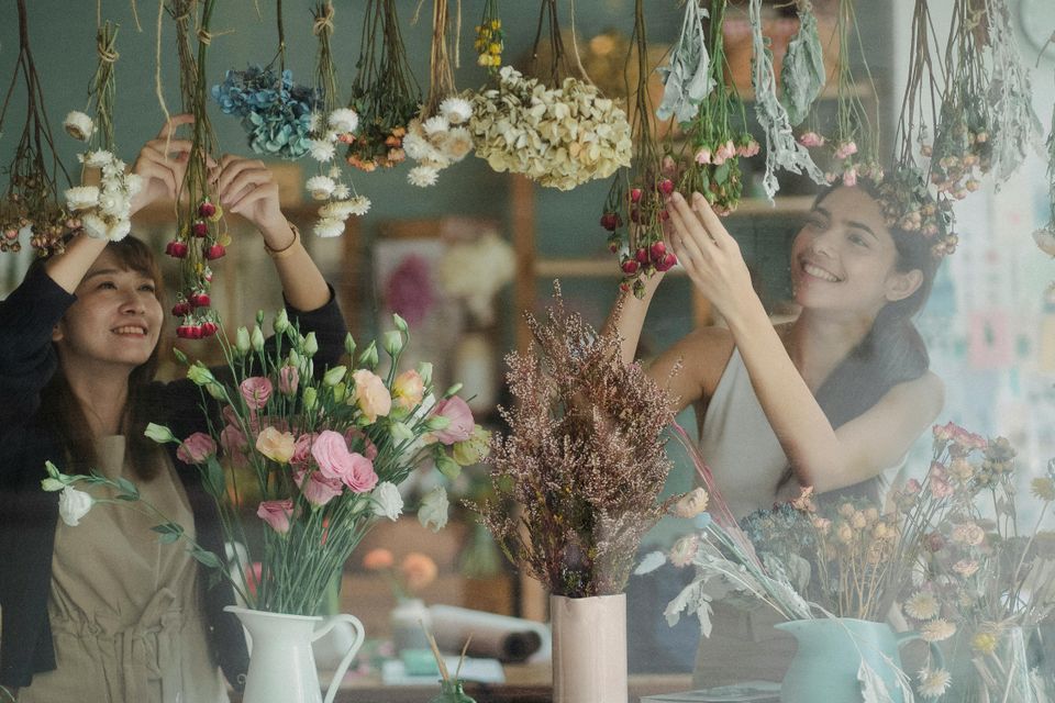 Two smiling business owners in their flower shop