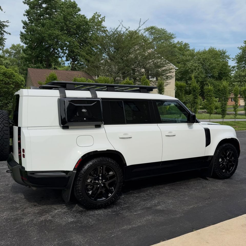 White Land Rover Defender 130 with roof rack shining after a mobile exterior detail in Wilmington