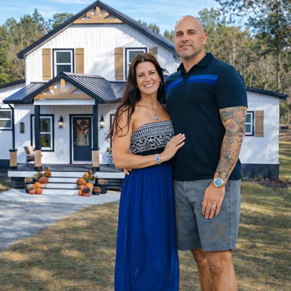 Lary and cory ellis of oceanside real estate team standing outside a coastal north carolina home