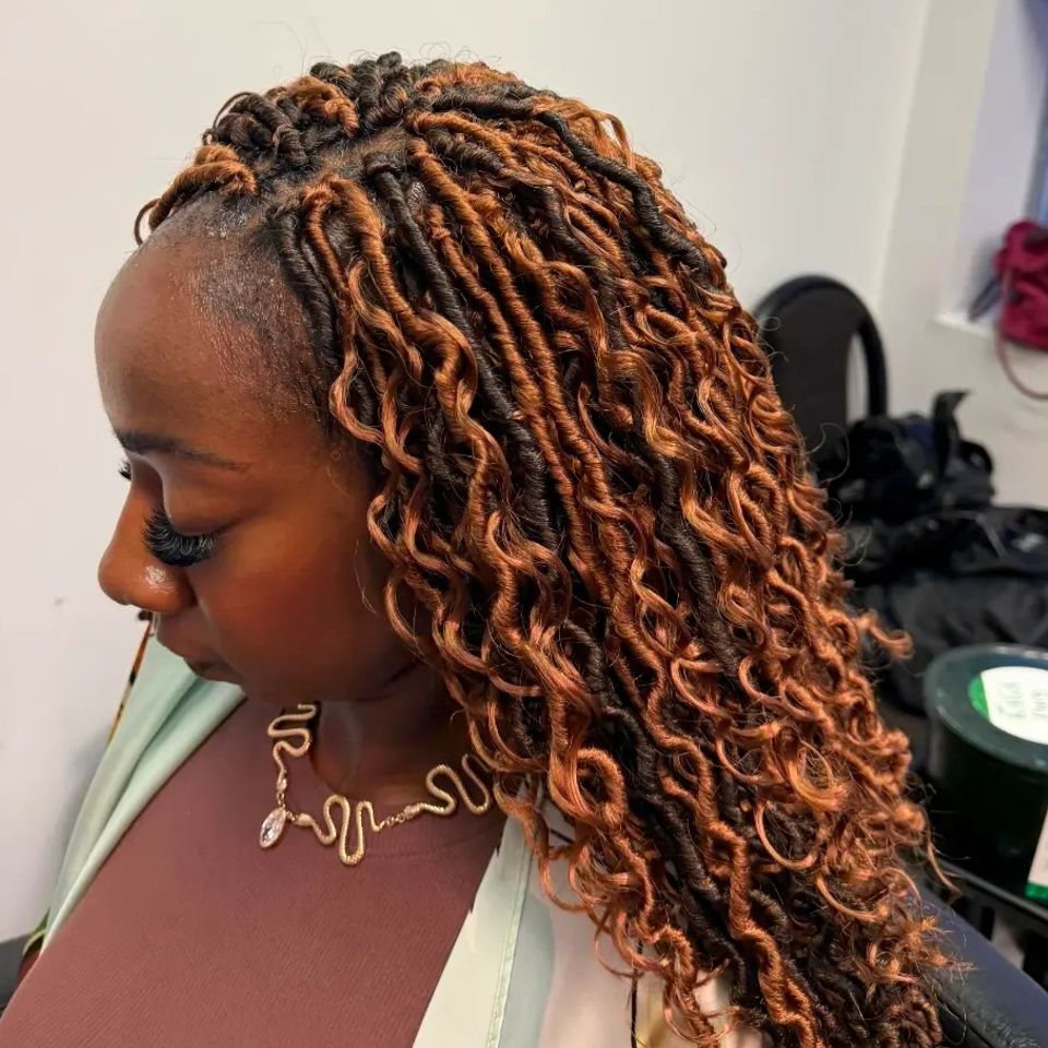 Copper colored distressed locs with curly ends after a braiding service in Los Angeles CA