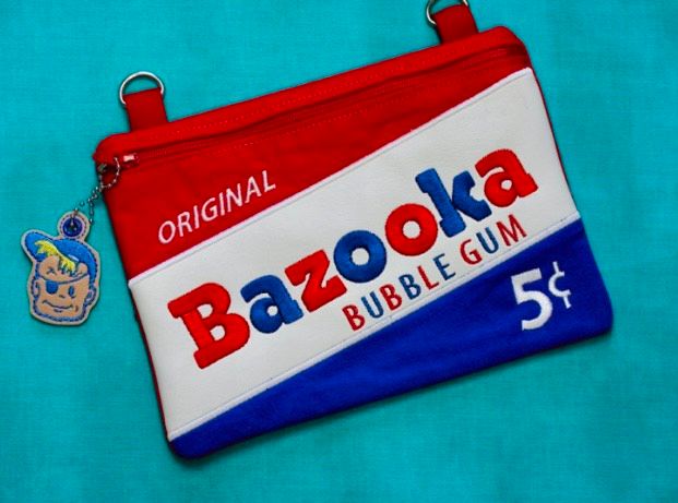 Custom embroidered zipper pouch designed to resemble a vintage Bazooka Bubble Gum wrapper with red, white, and blue colors.