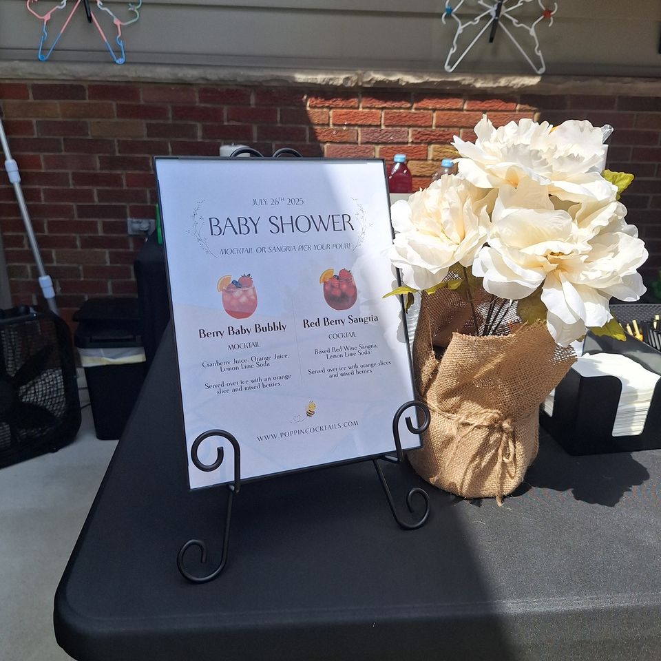 Baby shower drink menu showing mocktail and sangria selections on display