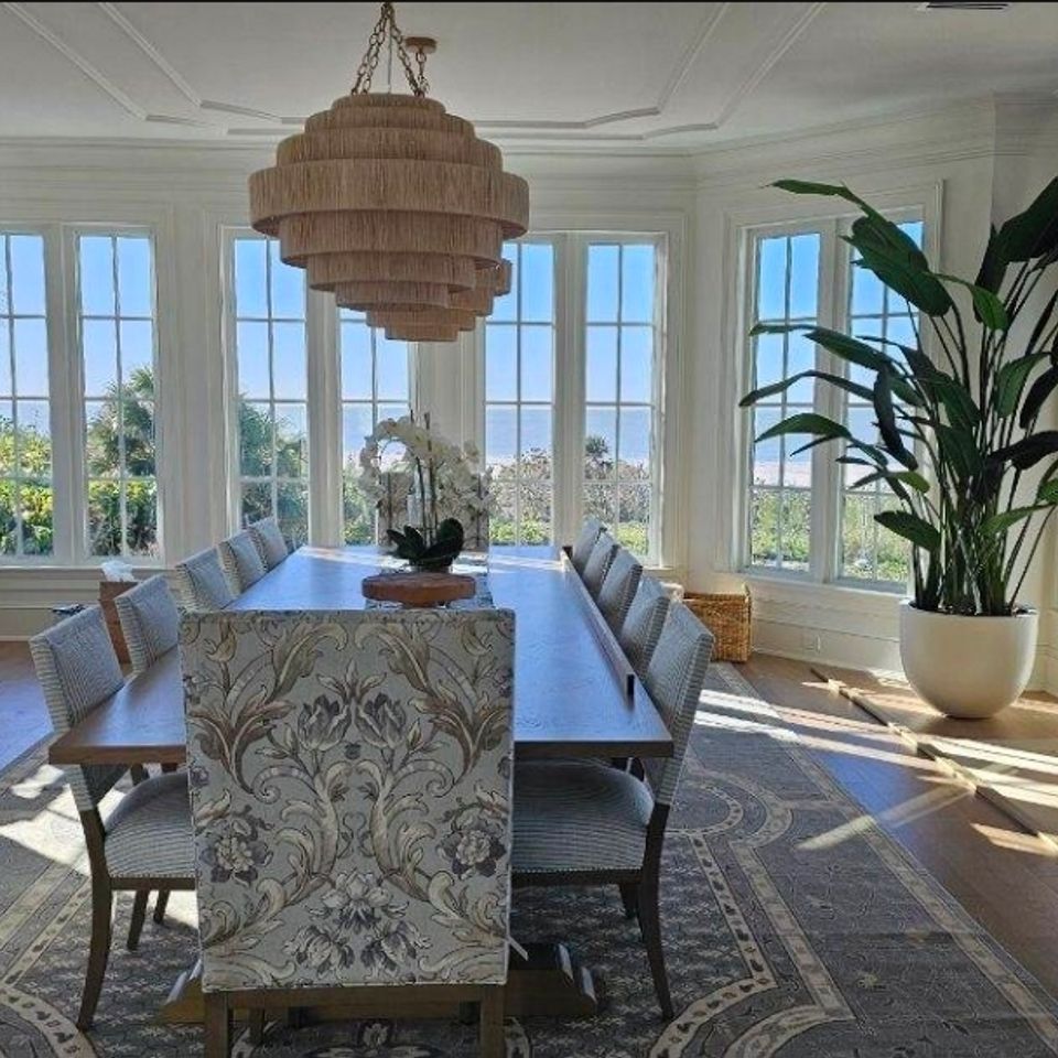 Bright dining room with long table and custom white trim installation around the windows