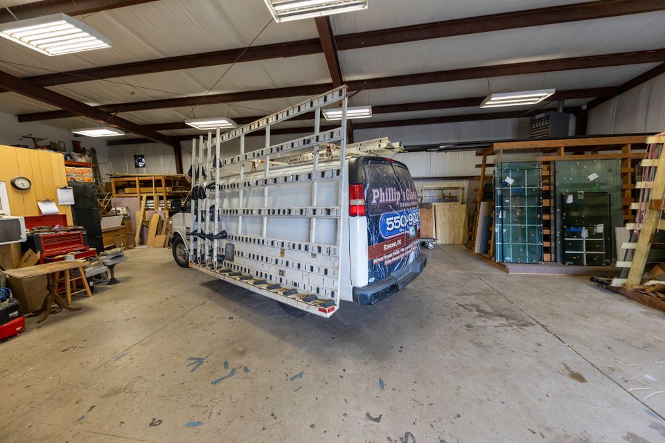 Wide interior view of the Phillip’s Glass workshop with a service truck and glass racks