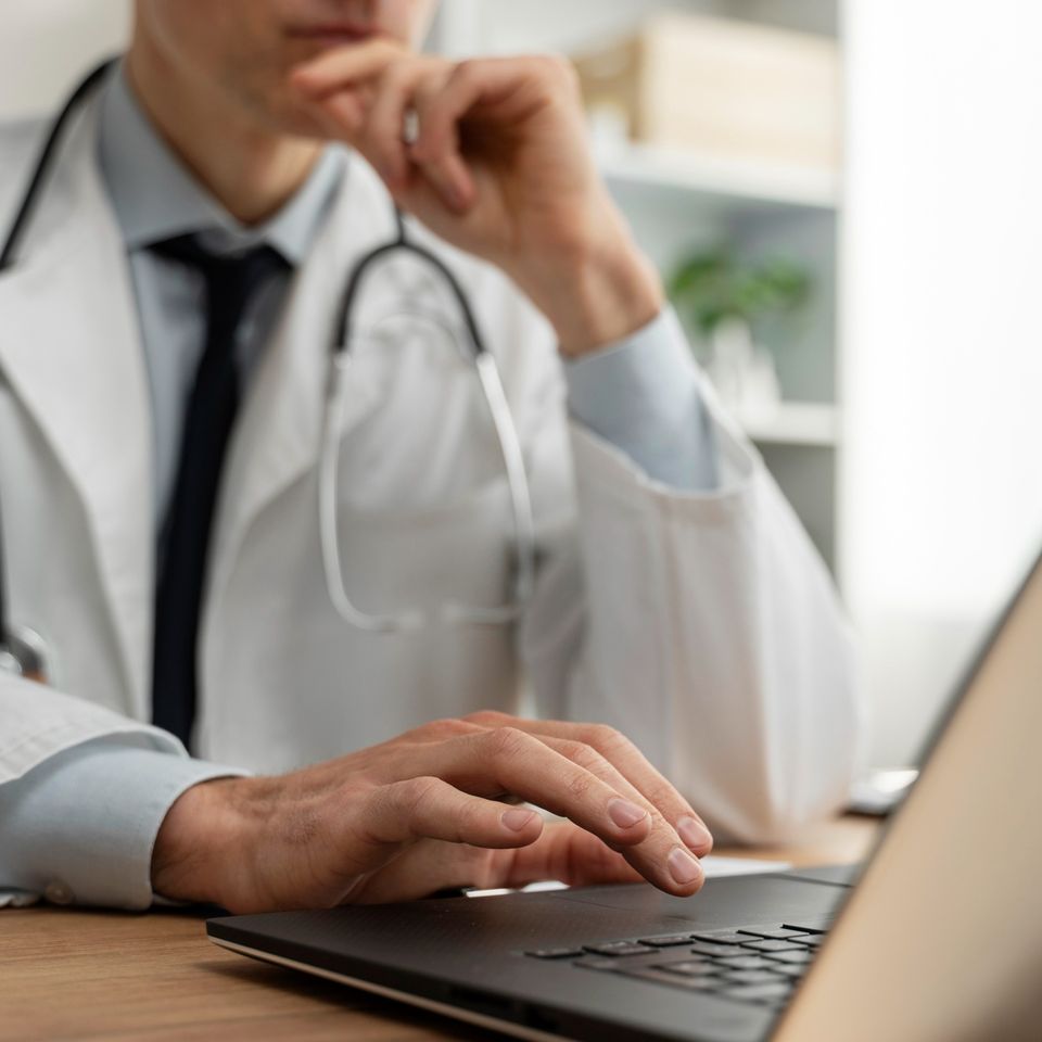 Doctor on a Computer Performing Data Collection