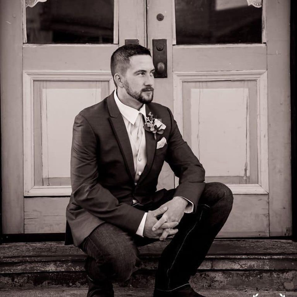 groom kneeling at The Coleman Vault
