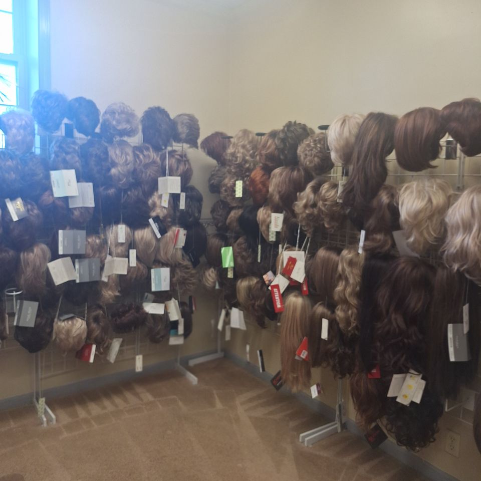 Wide selection of wigs displayed throughout Shears Wigs & Hairpieces Salon, showcasing numerous colors, lengths, and styles available for clients.