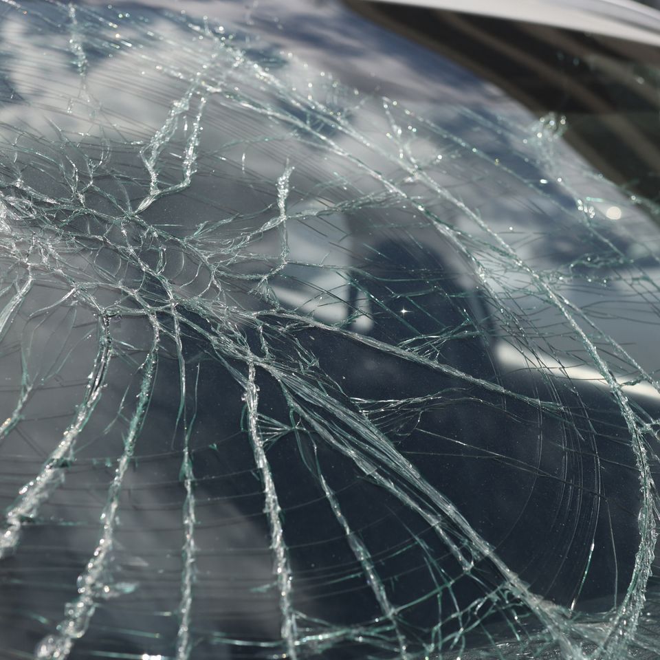 Closeup cracks broken car windshield car insurance concept