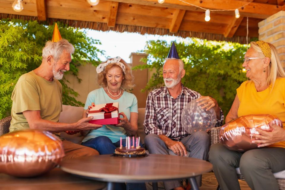 Elderly people opening presents at birthday party