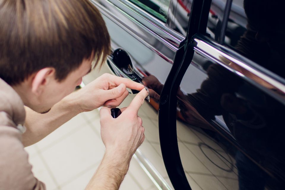 Locksmith performing car door lock replacement, skillfully changing locks