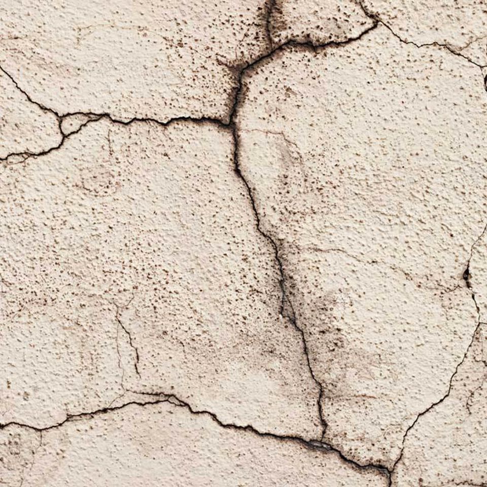 Homeguide close up view of cracked stucco exterior wall both hairline and wide