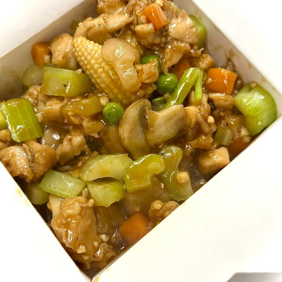 Asian-inspired entrée featuring mixed vegetables and protein in a savory brown sauce inside a takeout container.
