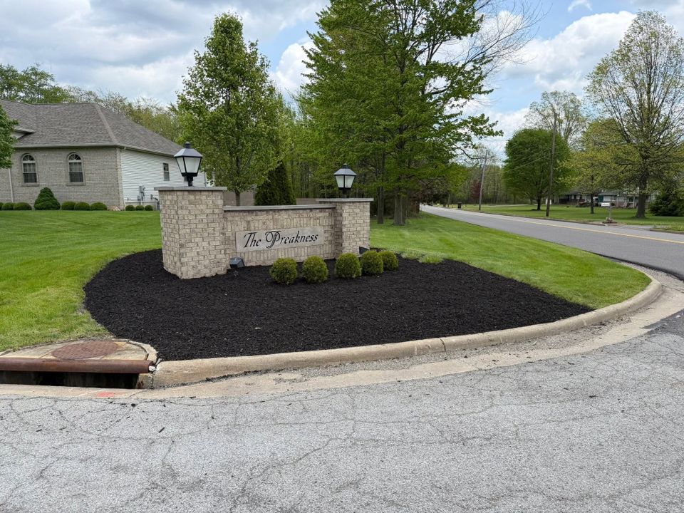 Commercial property with decorative mulch landscaping, trimmed shrubs, and a well-maintained lawn.