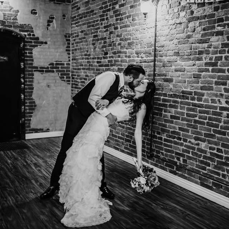Groom kissing bride off her feet