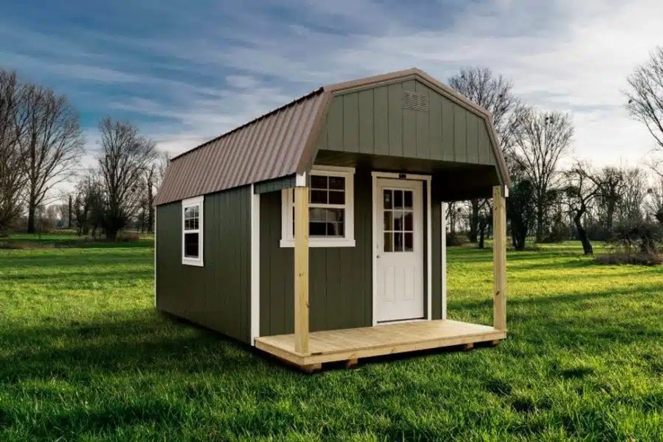 Olive green Dutch cabin with covered porch and gambrel metal roof in Elizabethton TN