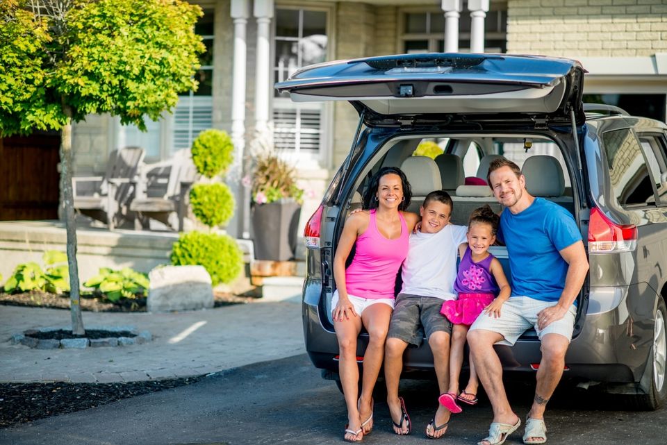 A happy family preparing for a road trip together in their car, protected by Stewart & Associates Insurance. Travel with peace of mind and coverage for your vehicle and passengers.