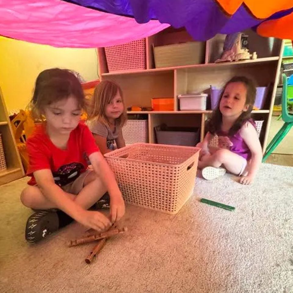 2 Pre-k 3 students playing in a tent area inside our facility