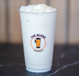 Pina Colada smoothie made with soy milk, coconut base, pineapple, banana, frozen yogurt, and shredded coconut.
