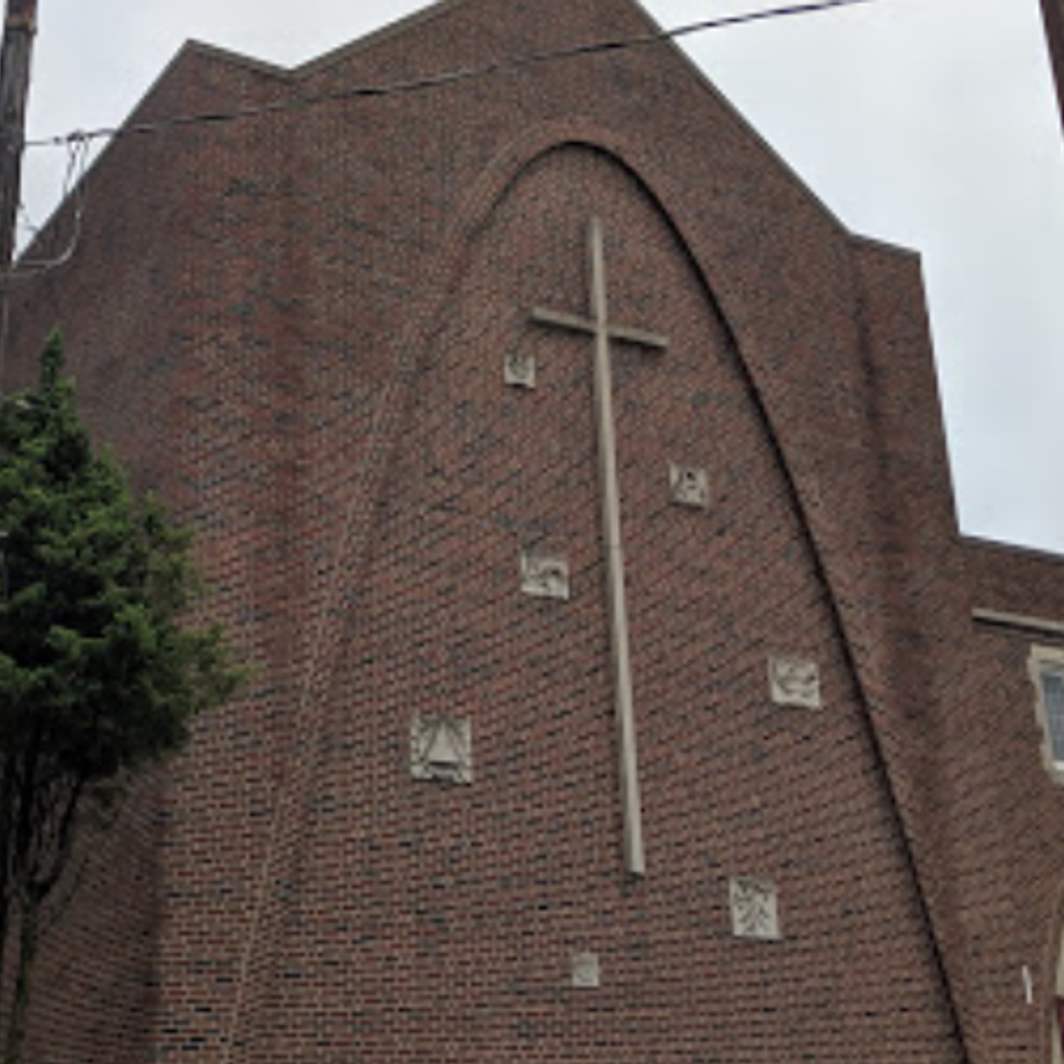 Exterior of Grace Evangelistic Temple Church featuring a brick façade and large cross, highlighting the church’s unique architectural design.