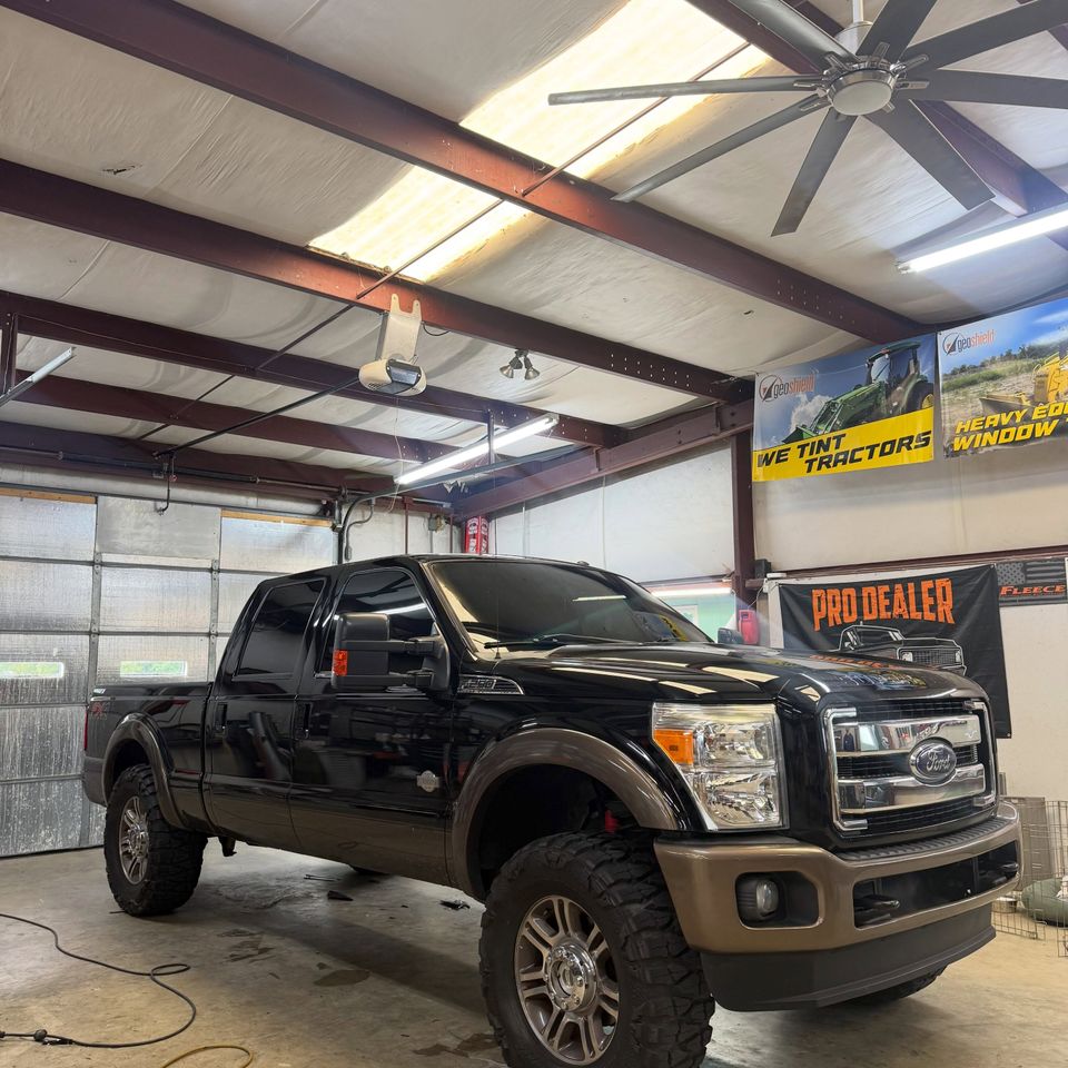 Black lifted Ford F-250 King Ranch with freshly installed auto window tint inside a Moyock NC tint shop