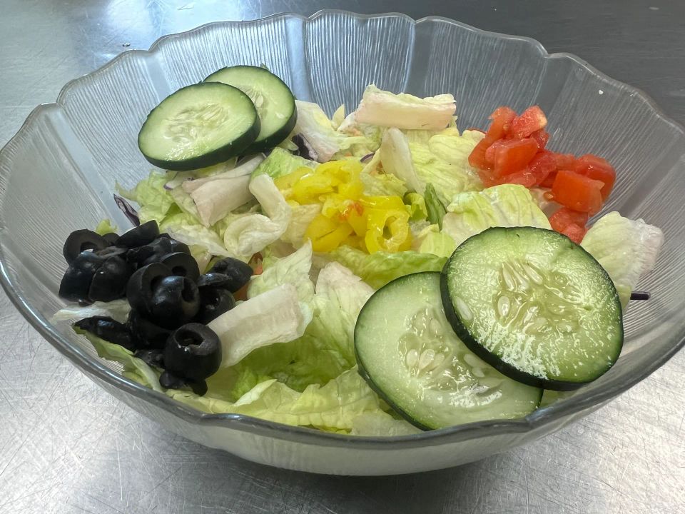 Garden Salad with lettuce, cucumbers, tomatoes, black olives, peppers, and cheese at Cocca’s Pizza.
