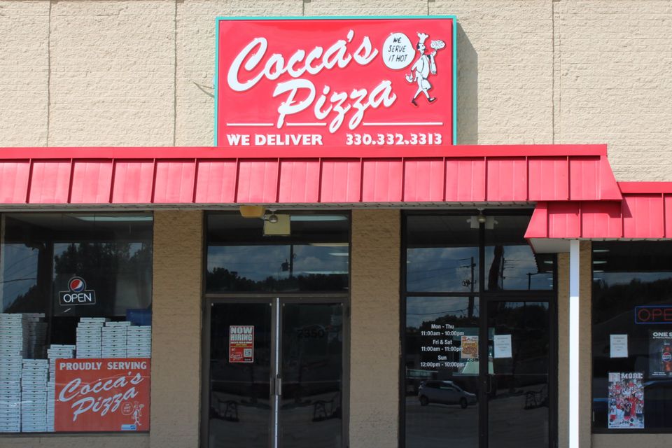 Cocca’s Pizza Salem, Ohio location featuring a tan exterior, red awning, glass entrance doors, and a large Cocca’s Pizza sign above the entrance.