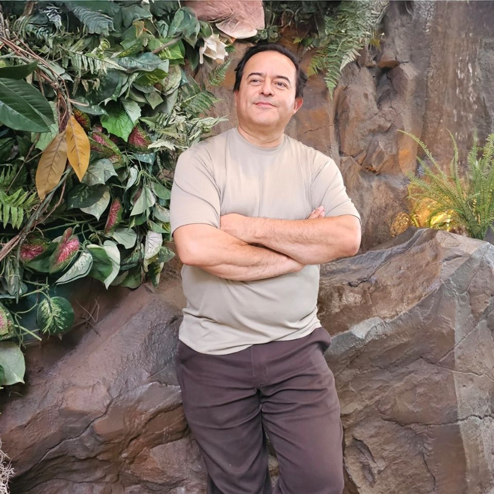 GloboWeb founder Samuel Nava leaning on a decorative rainforest outcropping as he contemplates ways his agency can help local businesses grow.