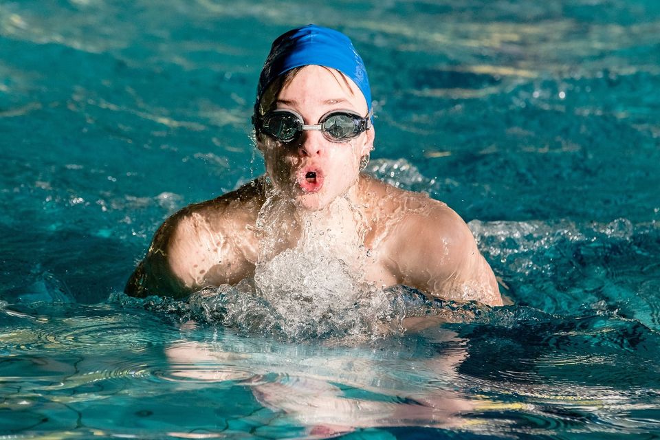 Young male swimmer in Austin TX catching breath after race, representing chiropractic support for athletic recovery