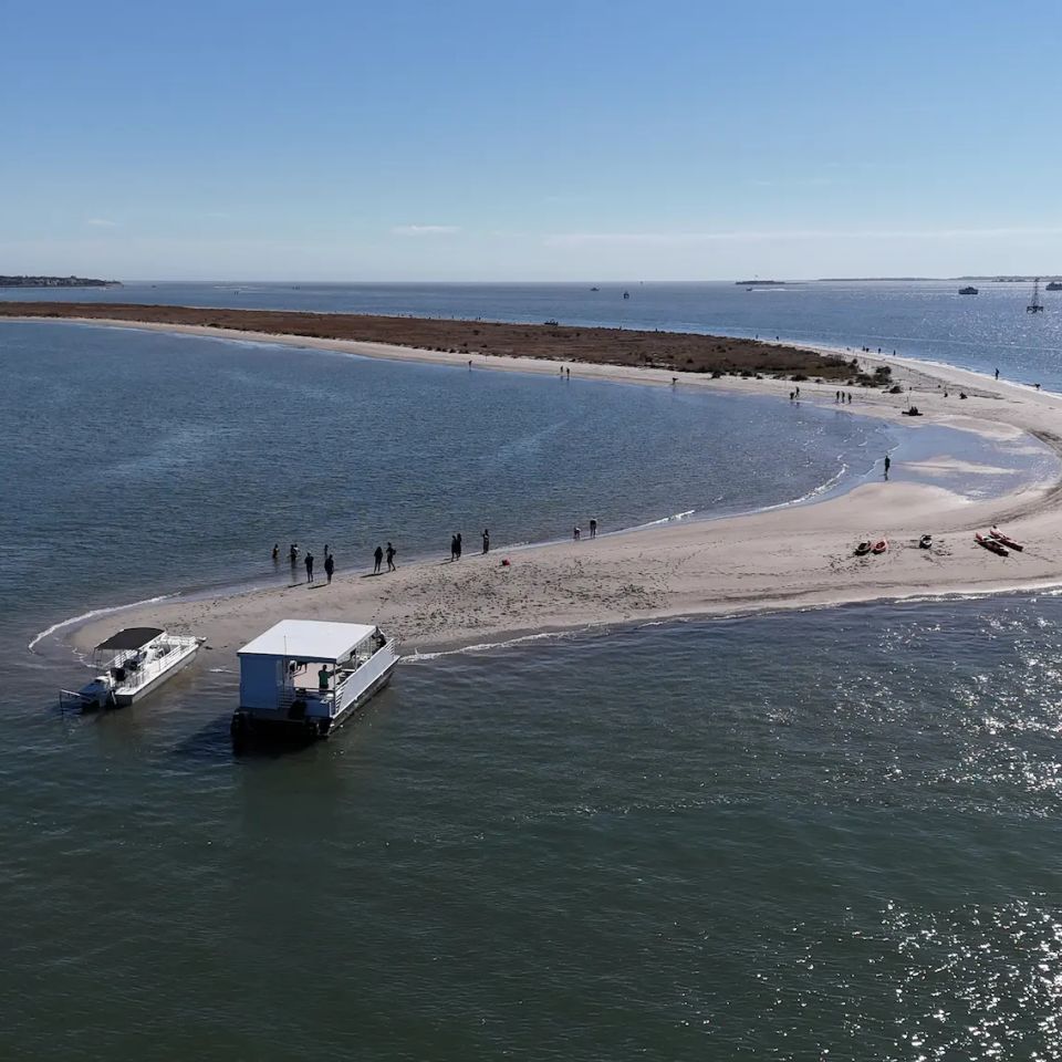 Private boat to beach charter at a Charleston barrier island sandbar with guests enjoying a secluded shoreline