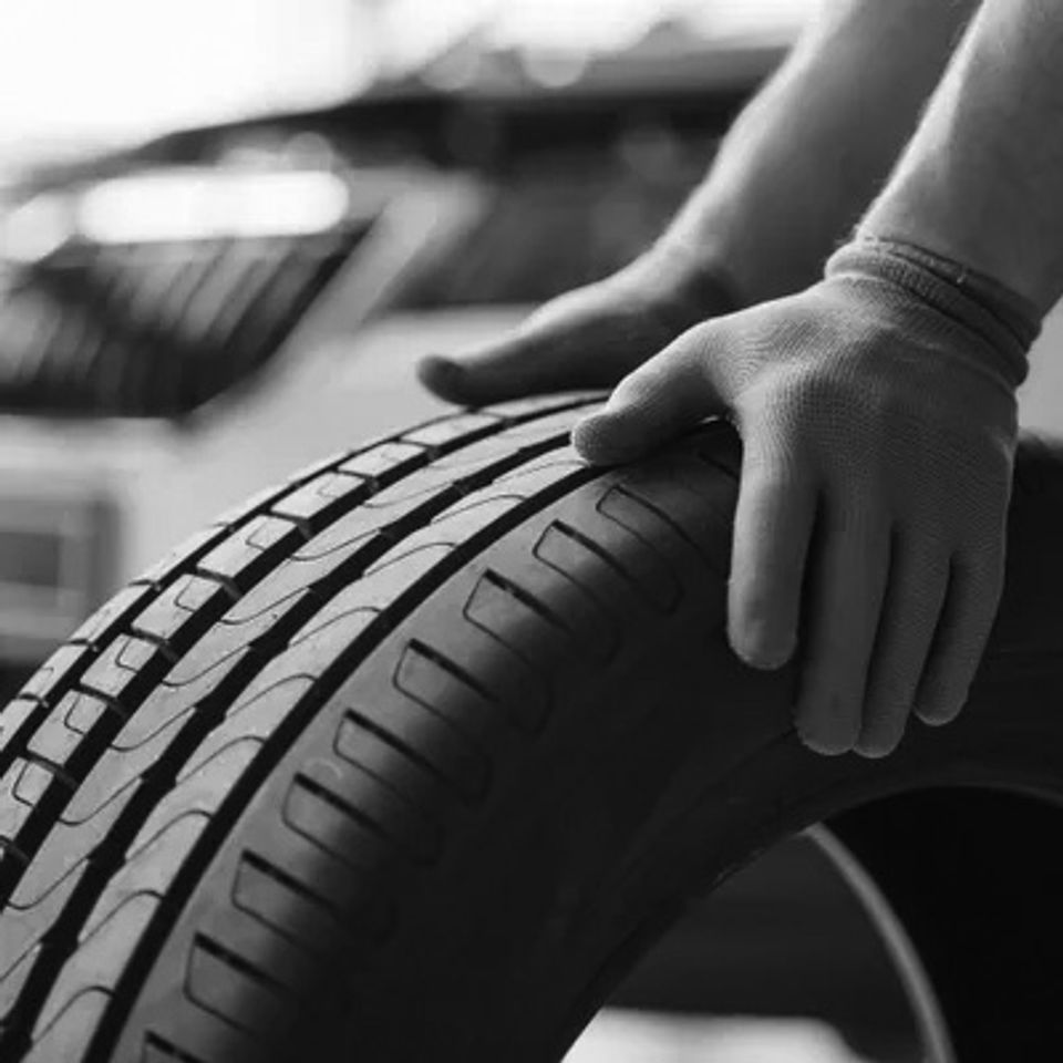 Hands only mechanic holding tire repair garage replacement winter summer tires original
