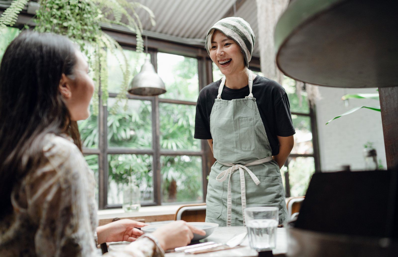 Restaurant server bringing a dish to a guest at her table