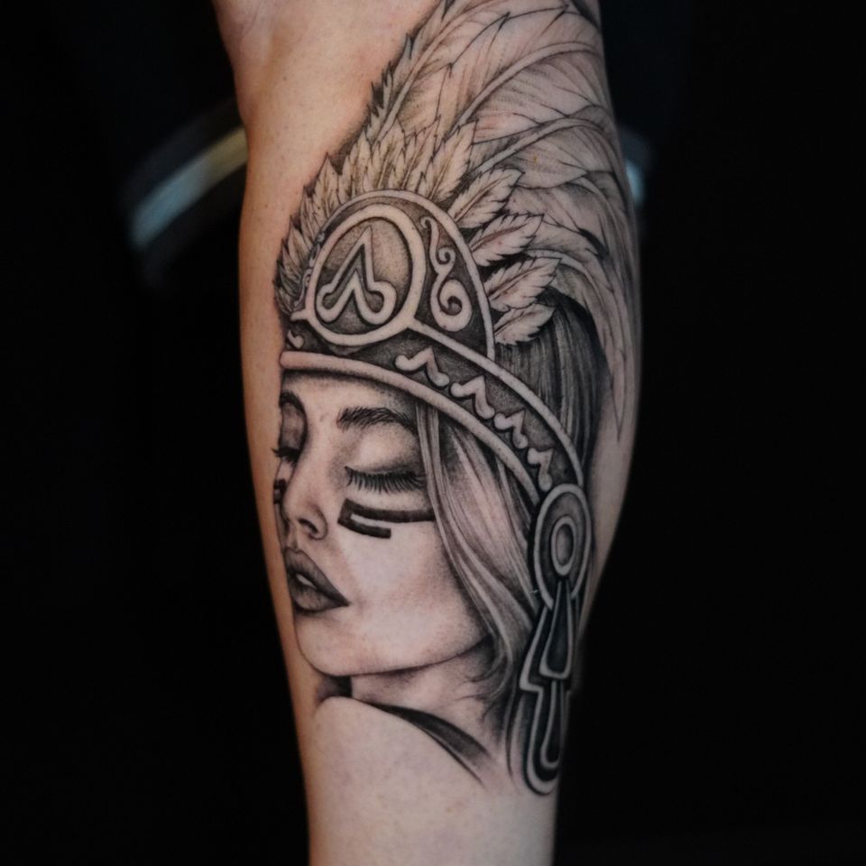 Image of a Native American woman wearing a very detailed feather headress