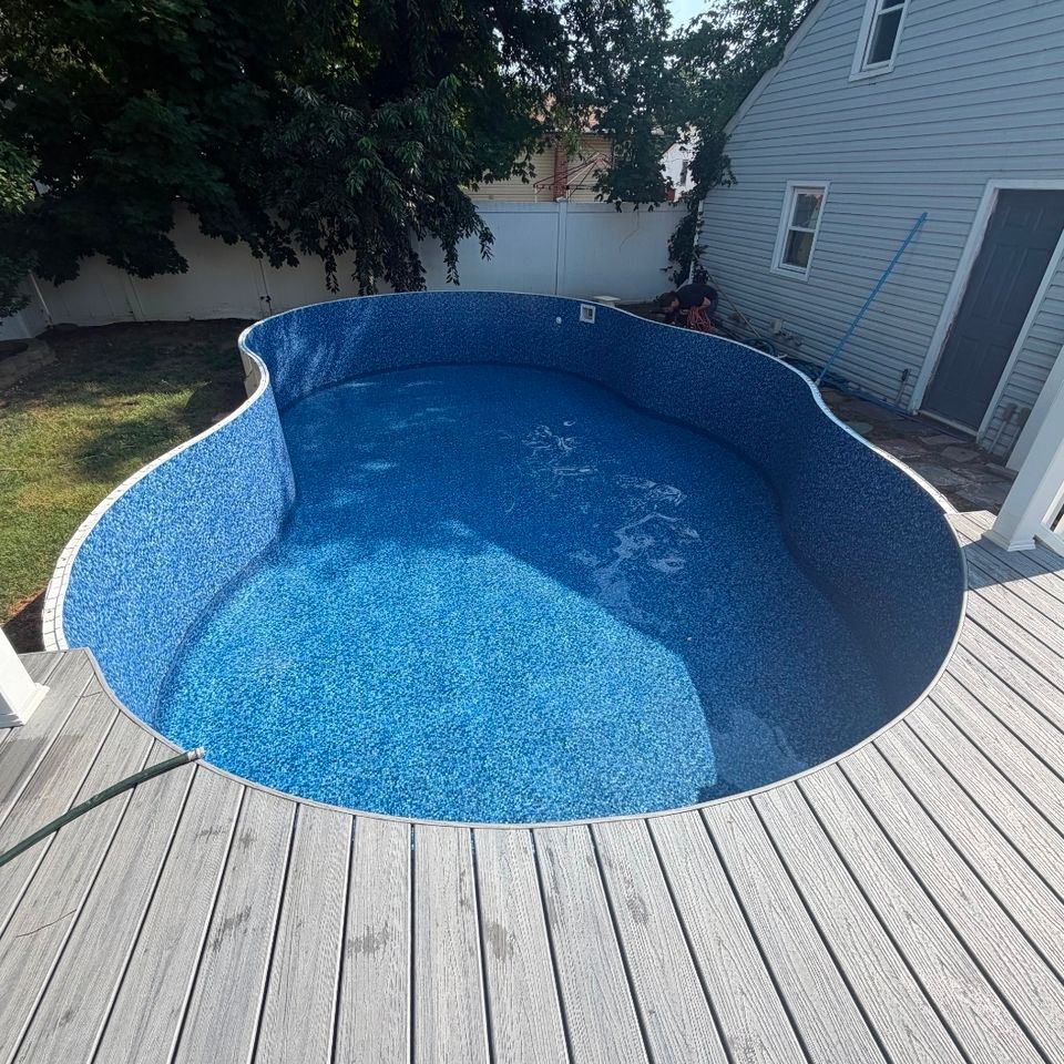 Freeform inground pool with new liner surrounded by a composite deck