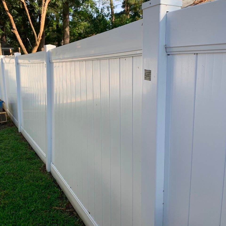 White vinyl privacy fence with decorative post caps installed along backyard in Virginia Beach VA