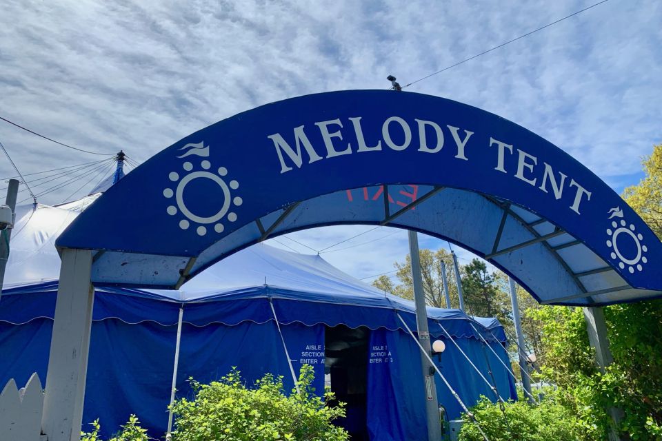 Arched blue Entrance with the words "melody tent"  in background a large blue tent