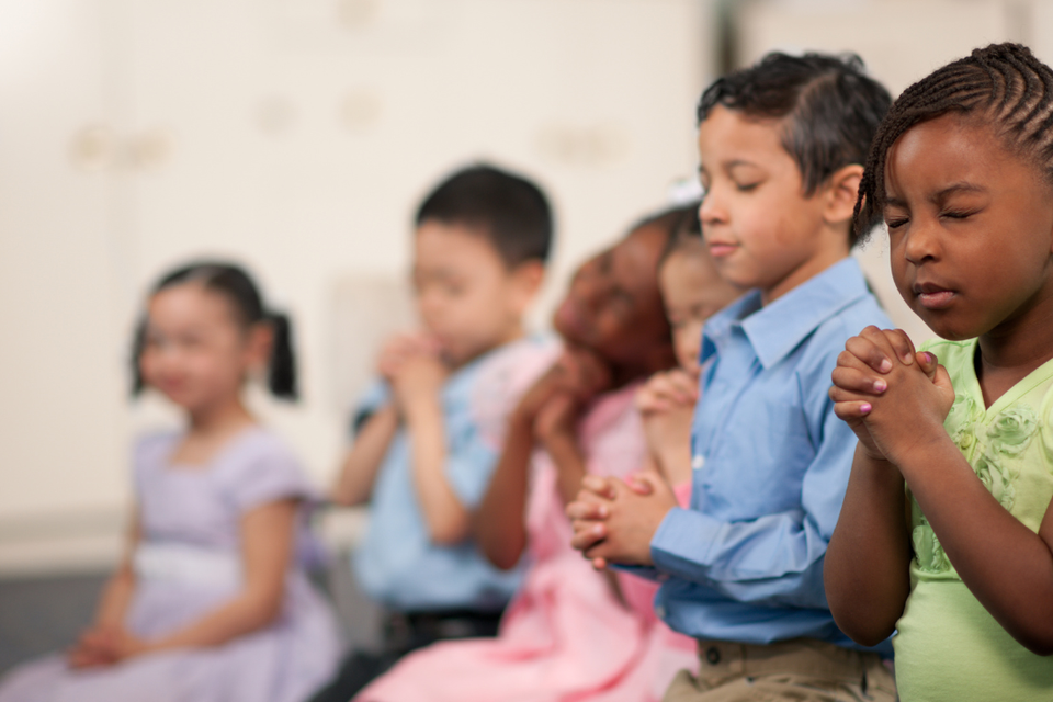 Children praying together during a church service or ministry program at Grace Evangelistic Temple Church.