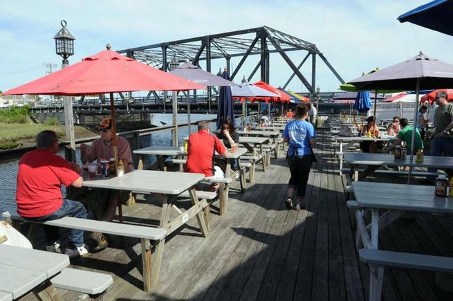 Outdoor deck dining at Bill's Seafood with views of Westbrook's Singing Bridge