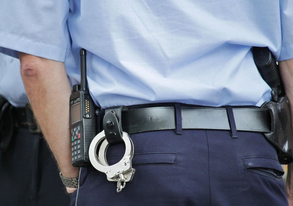 view of backside of police office with handcuffs and radio