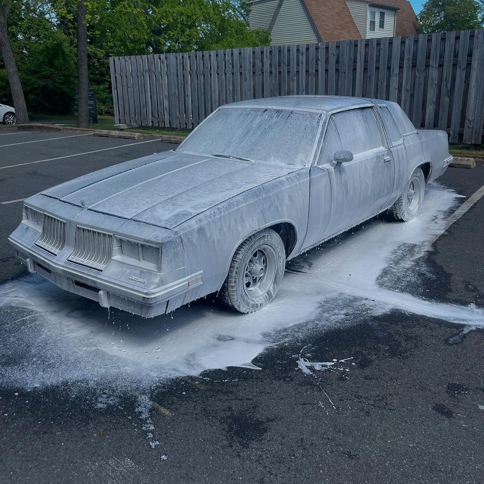 Oldsmobile Cutlass Supreme covered in thick snow foam during a mobile exterior wash in Wilmington DE