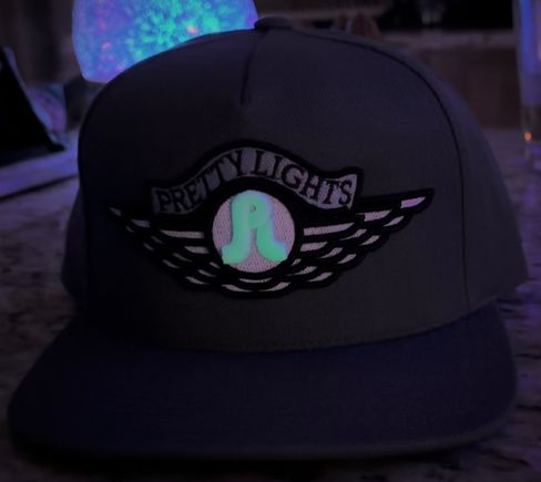 LOT Pretty Lights flatbill hat featuring the glow in the dark PL in the embroidered Pretty Lights/wings logo