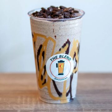 Chocolate and caramel protein smoothie in a clear cup with The Blend Smoothies logo