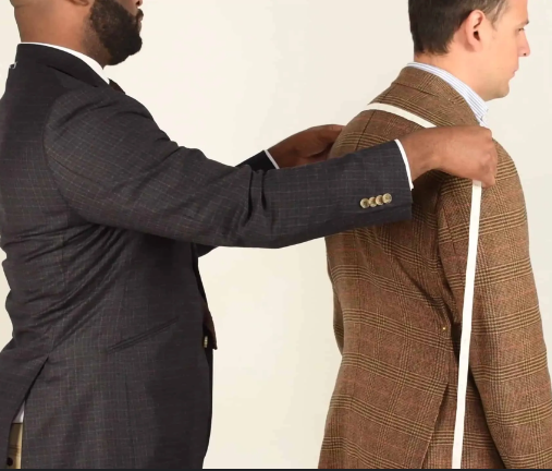 Black tailor taking measurements