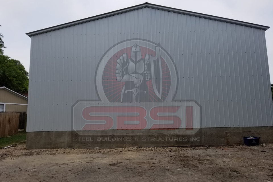 Gray steel building side wall on block foundation with SBSI watermark representing steel buildings in Alabama