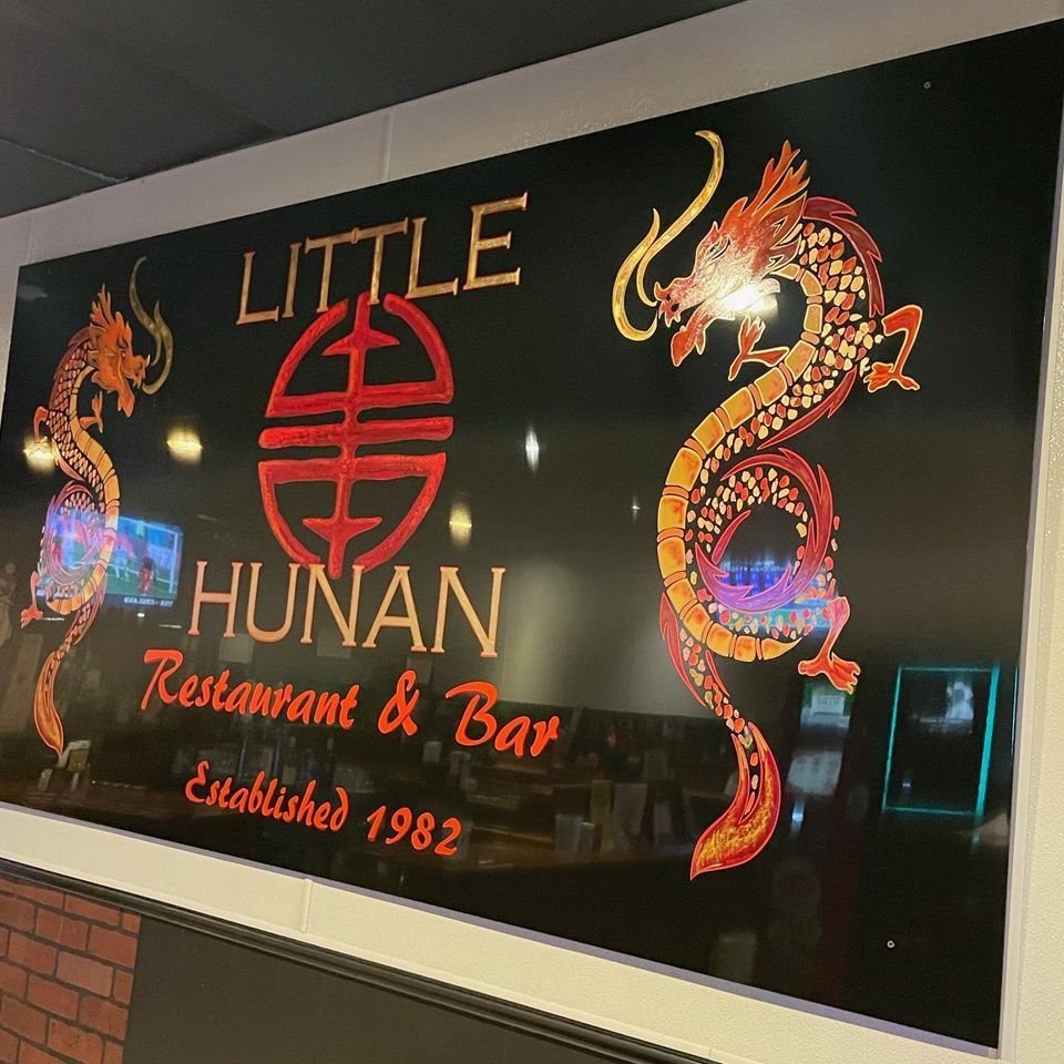 Little Hunan Restaurant & Bar wall sign with dragon artwork and restaurant logo.