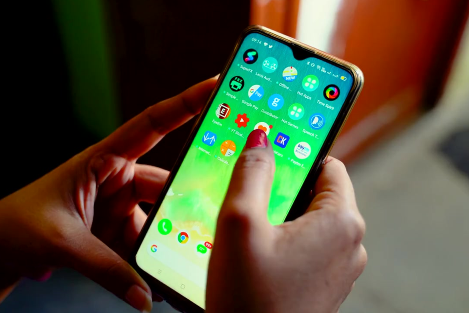 Hands interacting with a mobile phone screen, demonstrating the seamless, app-like experience of a high-performance PWA front-end application.