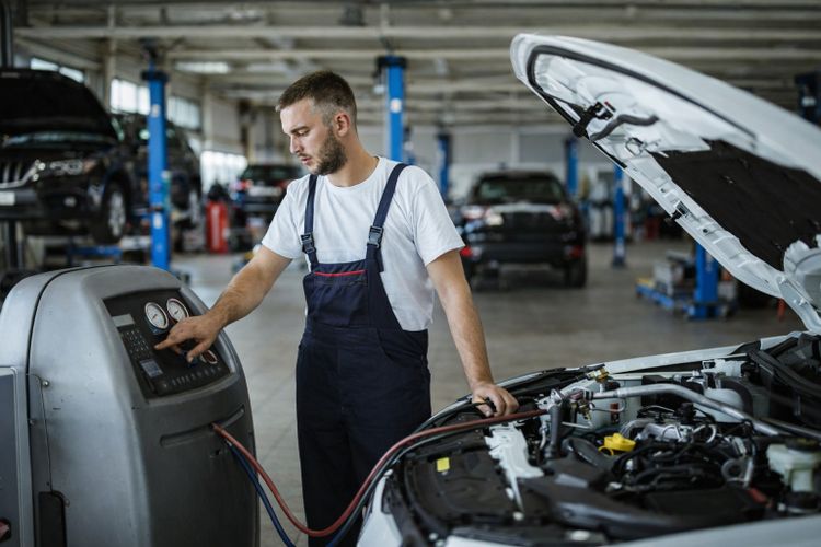 Mechanic repairing vehicle climate control system in Missouri City TX