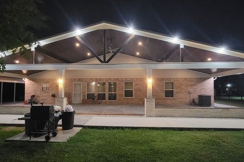 Night view of finished patio featuring vaulted steel truss in Magnolia, TX