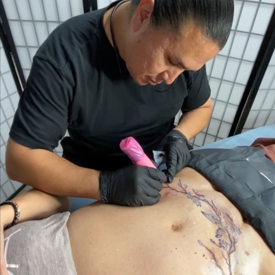 Image of Adrian Anderson creating a tummy tuck tattoo