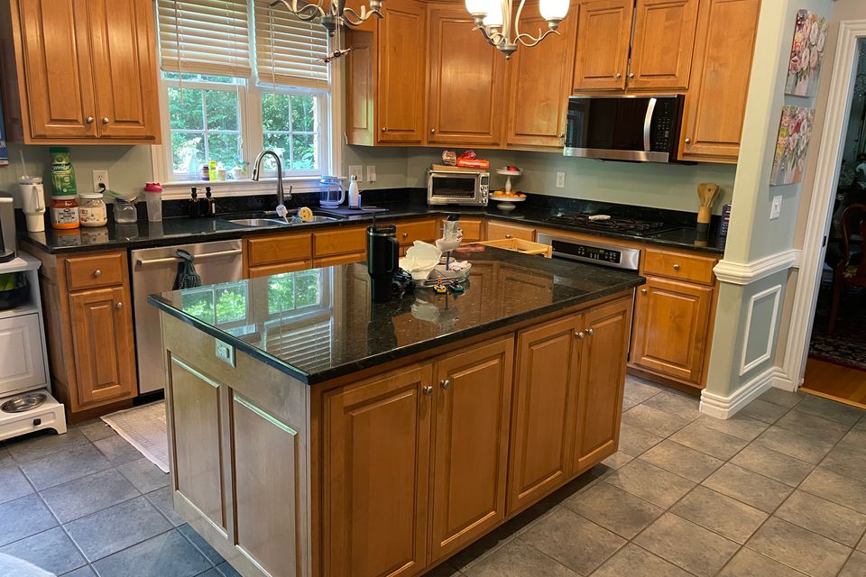 Clean kitchen with granite island and stainless steel appliances after a house cleaning service in Virginia Beach VA