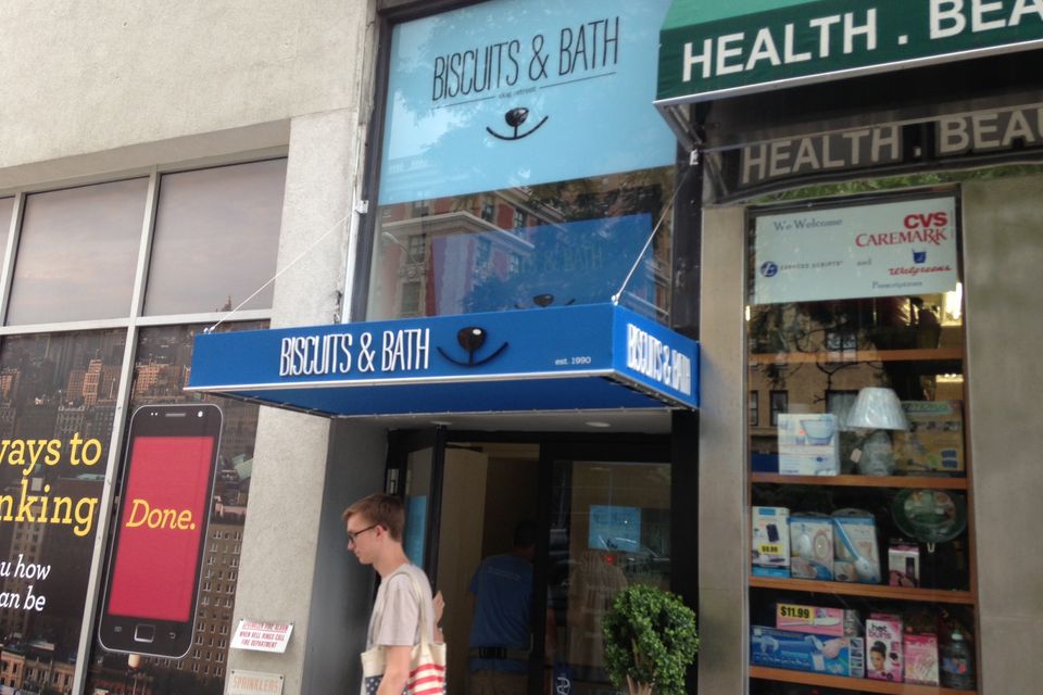 Blue storefront awning and matching entrance canopy with printed lettering on a Manhattan retail block